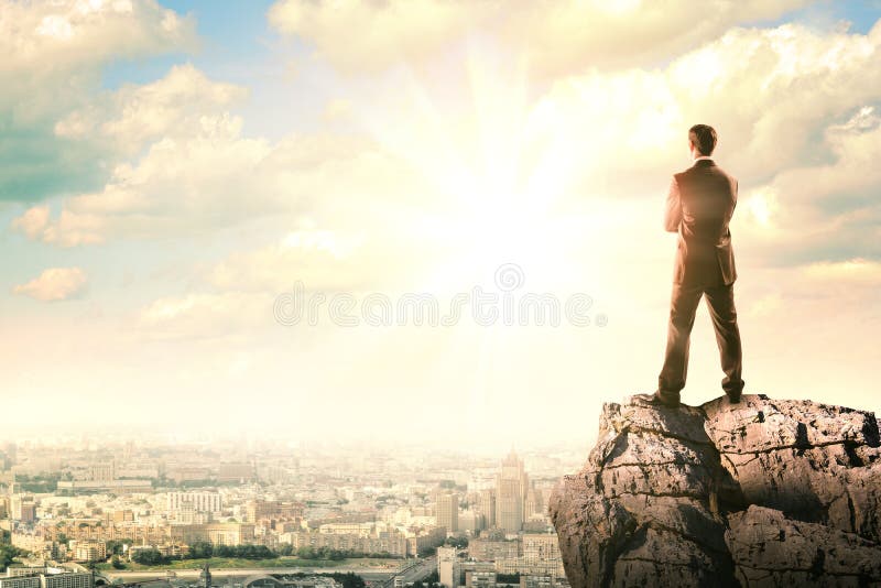 Businessman with suitcase looking at sunset royalty free stock photography