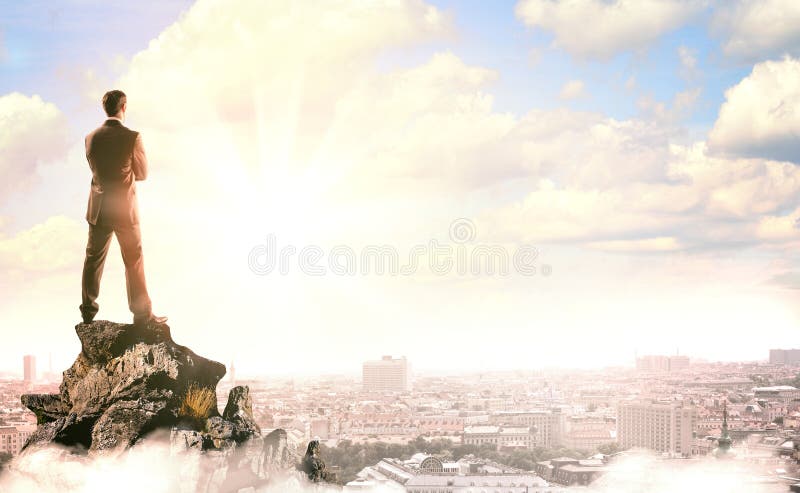 Businessman with suitcase looking at sunset stock image