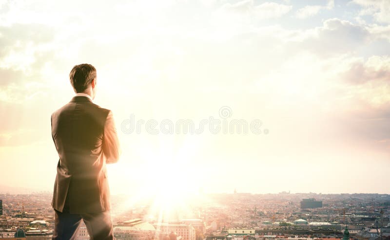 Businessman with suitcase looking at sunset royalty free stock image