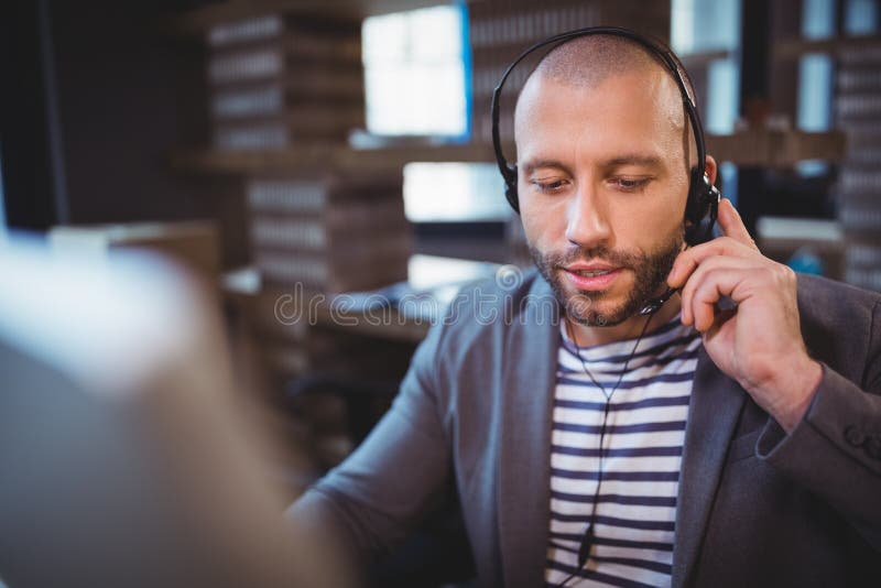 Businessman Talking on Headphones in Creative Office Stock Photo