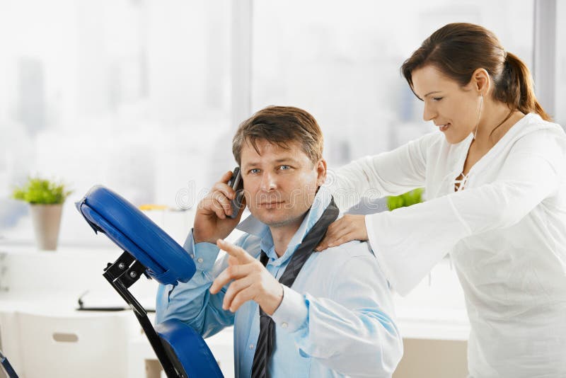 Businessman talking on phone during massage royalty free stock image