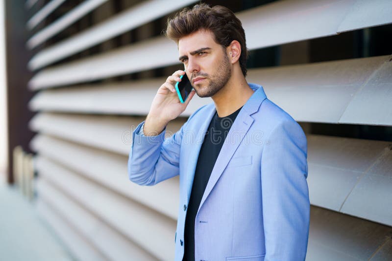 Businessman talking to his smartphone wearing blue suit.