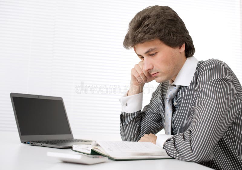 Businessman thinking while working on laptop