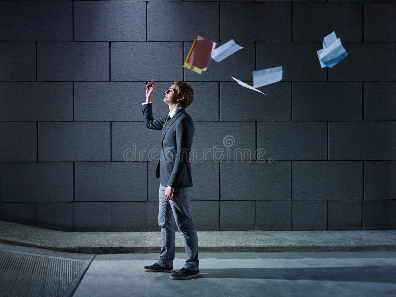 Young business man walking out from office parking and throwing away paperworks. Horizontal shape, side view, copy space. Young business man walking out from office parking and throwing away paperworks. Horizontal shape, side view, copy space