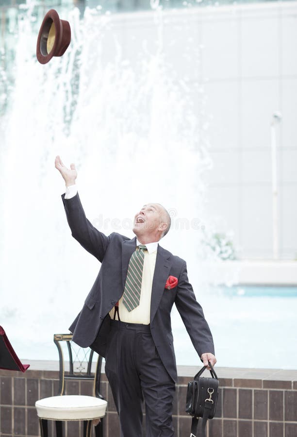 Businessman tossing his hat