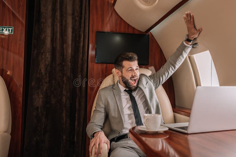 Businessman touching wall while sitting in private plane