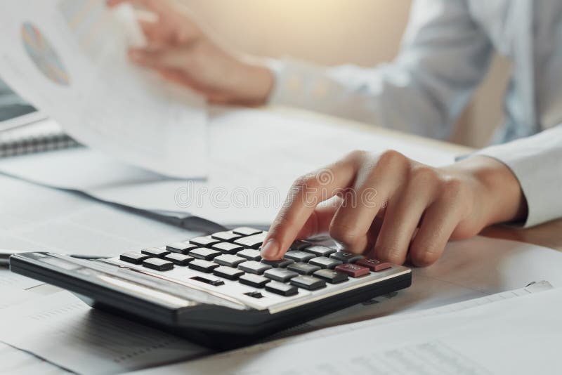 businessman using calculator for calculate budget on table in of
