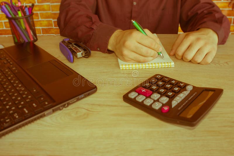 Businessman using a calculator to calculate the numbers. Businessman calculate finance and thinking about problem in home office - Retro color