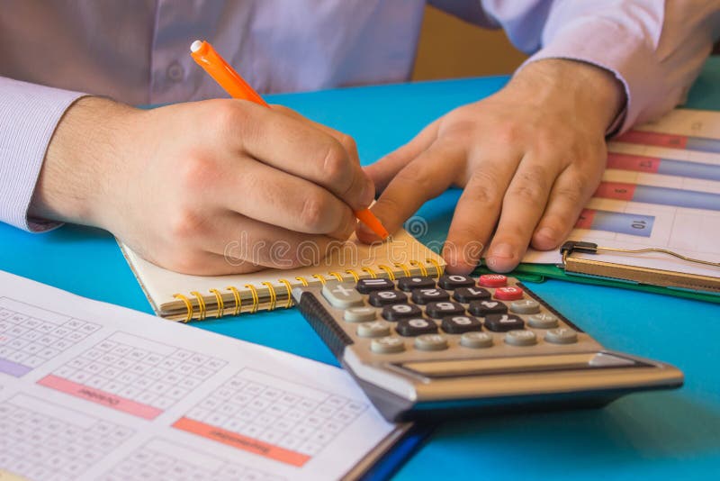 Businessman Using a Calculator To Calculate the Numbers. Accounting