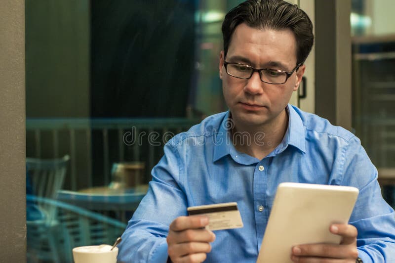 Businessman using a credit card and digital tablet for buying on internet. Businessman using a credit card and digital tablet for buying on-line. Man buying on stock images Businessman using a credit card and digital tablet for buying on internet. Businessman using a credit card and digital tablet for buying on-line. Man buying on stock images