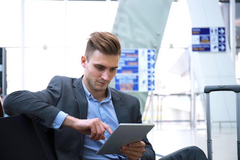 Businessman Using Digital Tablet in Airport Departure Lounge. Stock Photo Image of modern