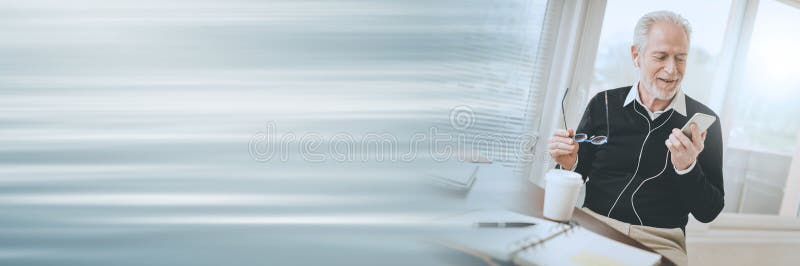 Businessman using earphones during conversation on mobile phone; panoramic banner stock photo Businessman using earphones during conversation on mobile phone; panoramic banner stock photo
