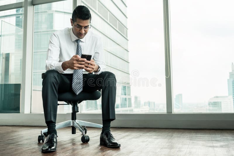 Businessman using a mobile phone while sitting down royalty free stock images Businessman using a mobile phone while sitting down royalty free stock images