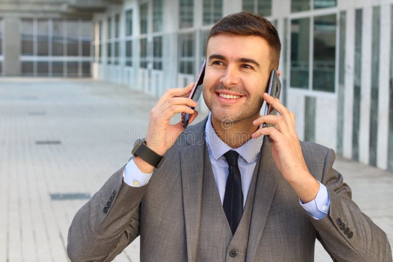 businessman-using-two-phones-simultaneously-businessman-using-two-phones-simultaneously-134011626.jpg