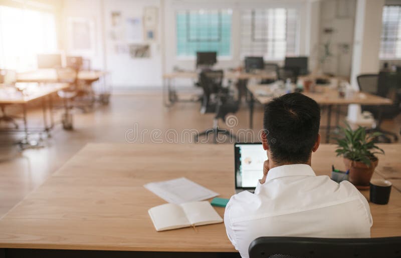 Businessman working alone in a large modern office