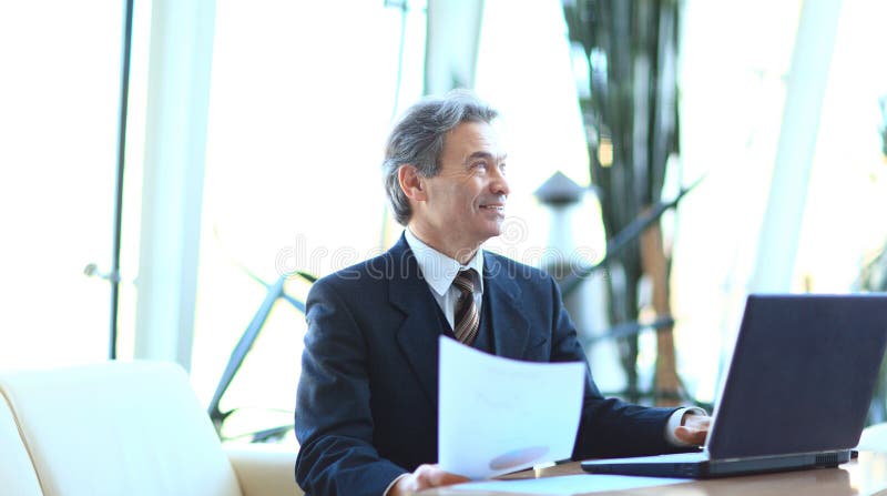 Businessman working with business documents sitting at his Desk.