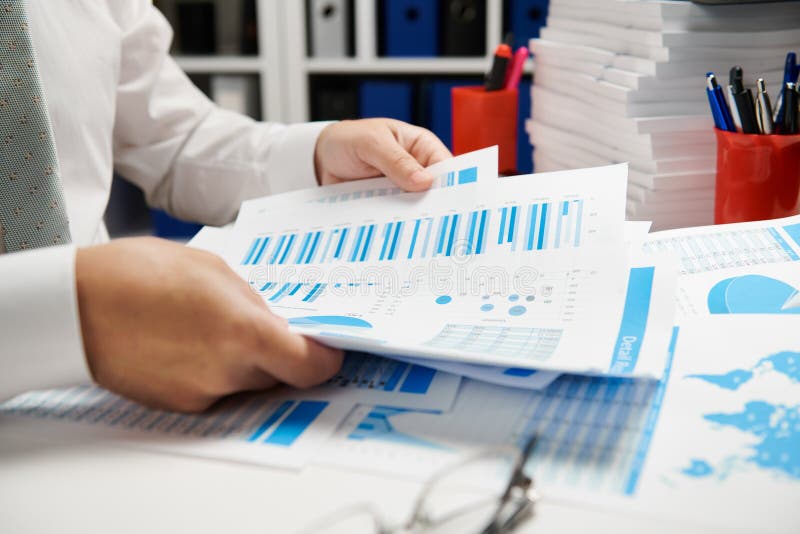 Businessman working and calculating, reads and writes reports. Office employee, table closeup. Business financial accounting