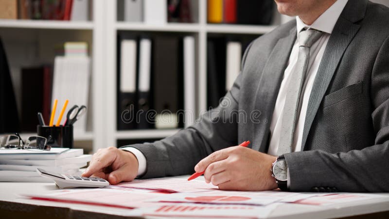 Businessman working and calculating, reads and writes reports. Office employee, table closeup. Business financial accounting