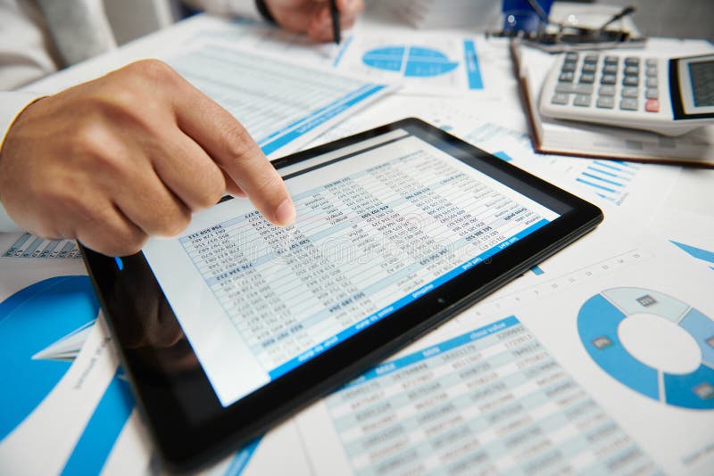 Businessman working and calculating, reads and writes reports. Using tablet pc. Office employee, table closeup. Business financial