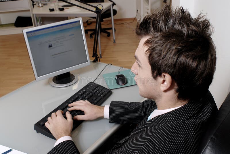Buscando través de hombro de joven emprendedor sobre el computadora mesa su manos sobre el computadora teclado.
