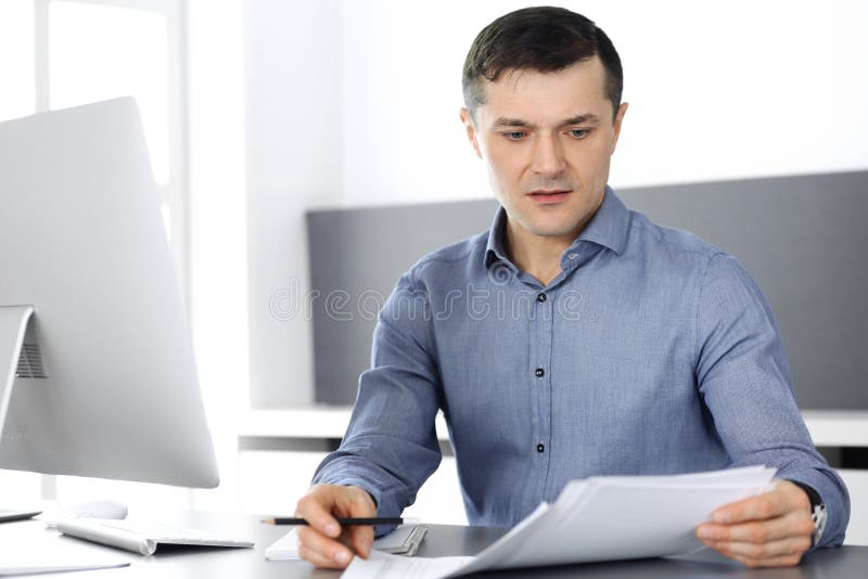 Businessman working with computer in modern office. Headshot of male entrepreneur or company director at workplace stock photography Businessman working with computer in modern office. Headshot of male entrepreneur or company director at workplace stock photography