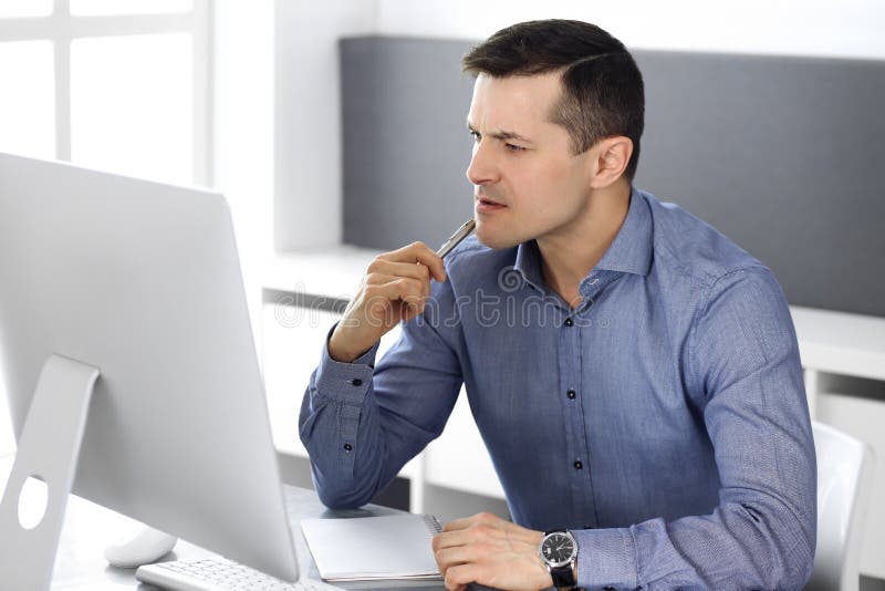 Businessman working with computer in modern office. Headshot of male entrepreneur or company director at workplace stock photos
