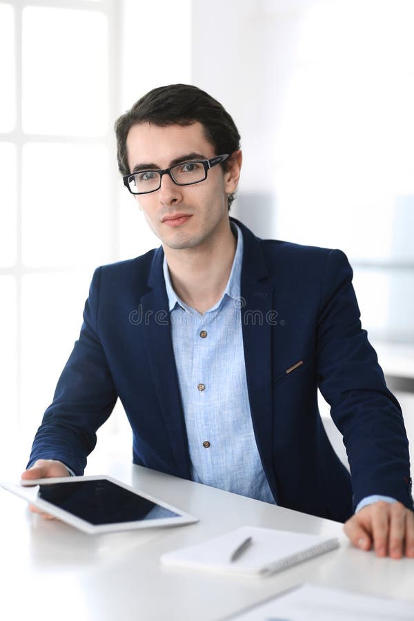 Businessman working with tablet computer in modern office. Headshot of male entrepreneur or company manager at workplace royalty free stock image