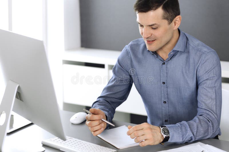 Businessman working with computer in modern office. Headshot of male entrepreneur or company director at workplace stock images