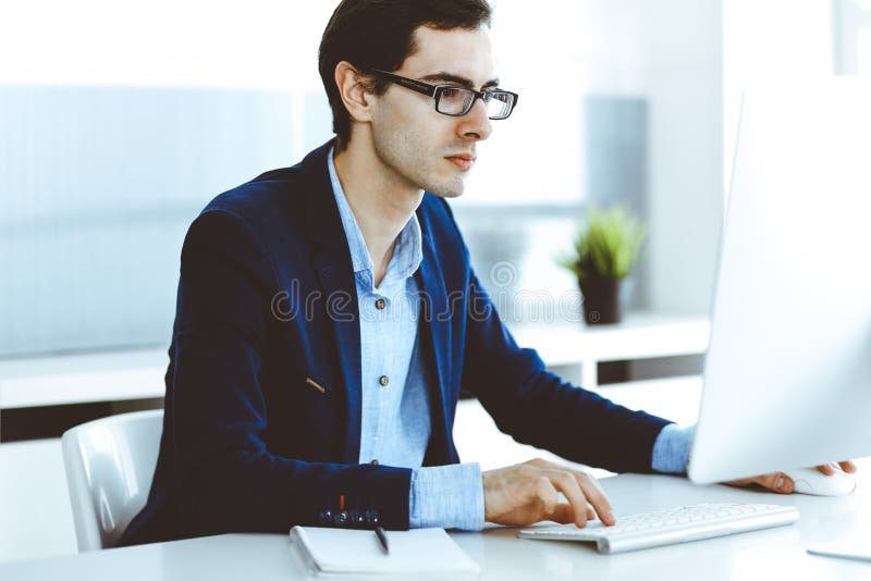 Businessman working with computer in modern office. Headshot of male entrepreneur or company manager at workplace royalty free stock photos