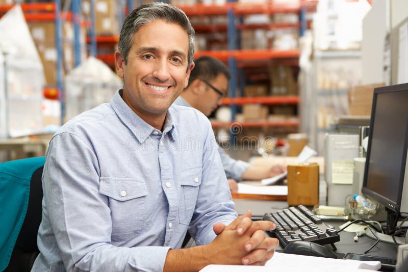 Businessman Working At Desk In Warehouse stock photography
