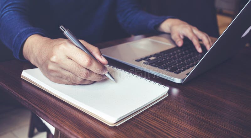Businessman working with laptop and notepad on desk table royalty free stock photo Businessman working with laptop and notepad on desk table royalty free stock photo
