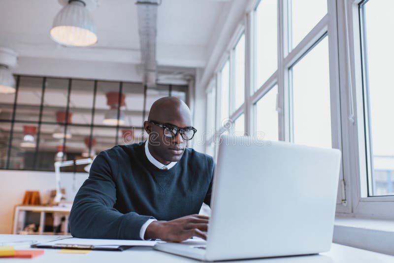 Businessman working on laptop in office stock image