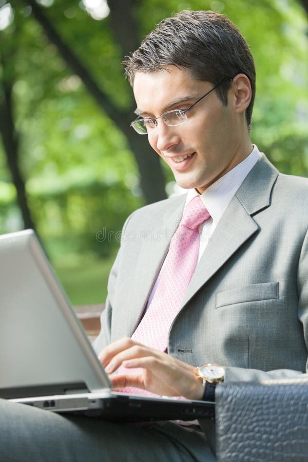 Happy businessman working notebook, outdoors. Happy businessman working notebook, outdoors