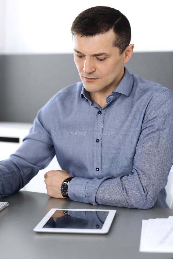 Businessman working with tablet computer in modern office. Headshot of male entrepreneur or company director at stock images