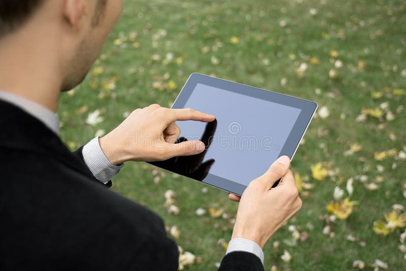 Businessman outdoors working with touch screen device. Male hand holding businessman stock images, royalty-free photos and pictures