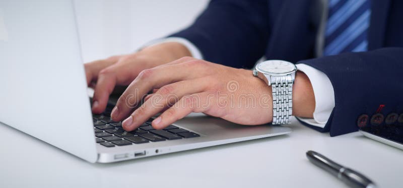 Businessman working by typing on laptop computer. Man`s hands on notebook or business person at workplace. Employment o stock photo