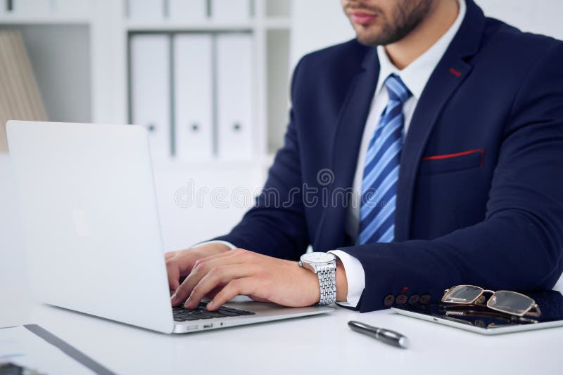 Businessman working by typing on laptop computer. Man`s hands on notebook or business person at workplace. Employment o royalty free stock photos