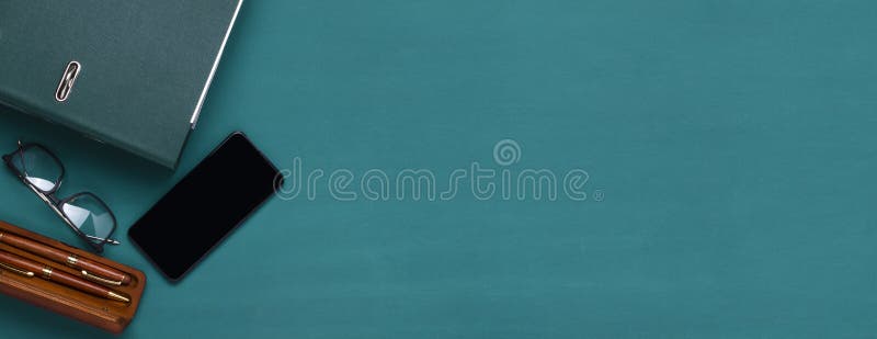 Top View of Green Holder for Documents, Glasses, Pen on the Dark Green