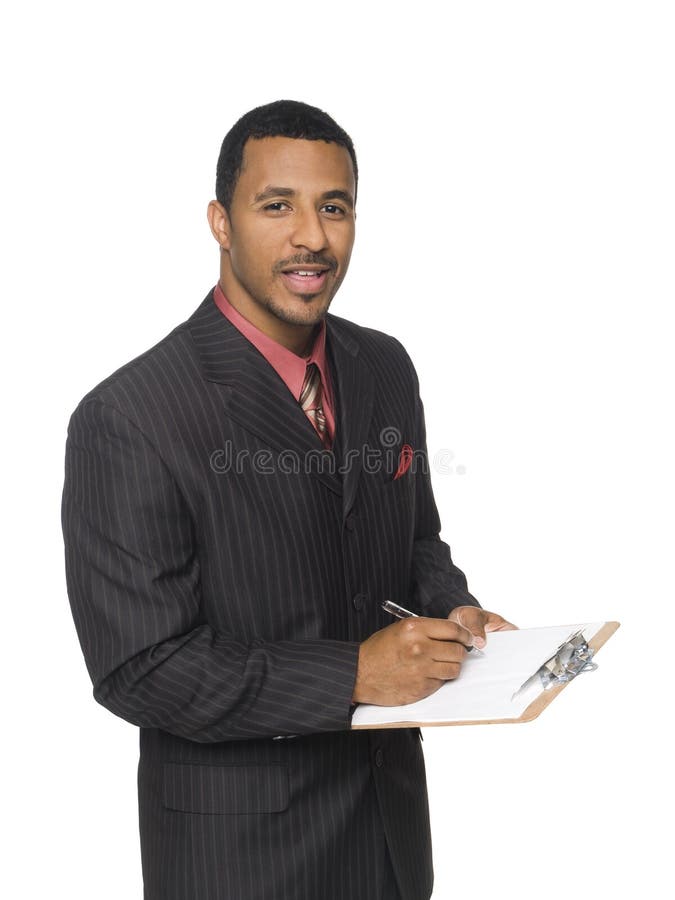 Isloated studio shot of an African American man looking at the camera while smiling and writing on a clipboard he is holding. Smiling asking stock images, royalty-free photos and pictures