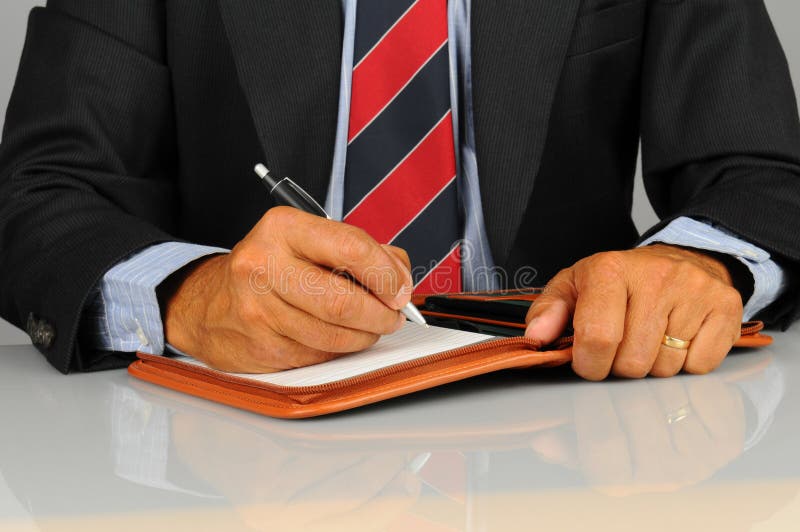 Businessman writing in note pad