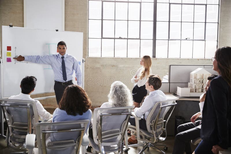 Businessmastands using whiteboard during a presentation royalty free stock photo Businessmastands using whiteboard during a presentation royalty free stock photo
