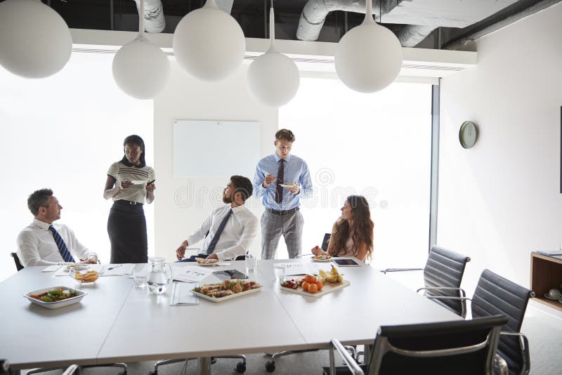 Businessmen and Businesswomen Meeting in Modern Boardroom Over Working