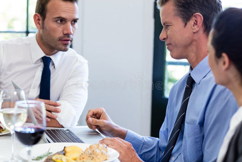 Businessmen Discussing during a Business Lunch Meeting Stock Photo