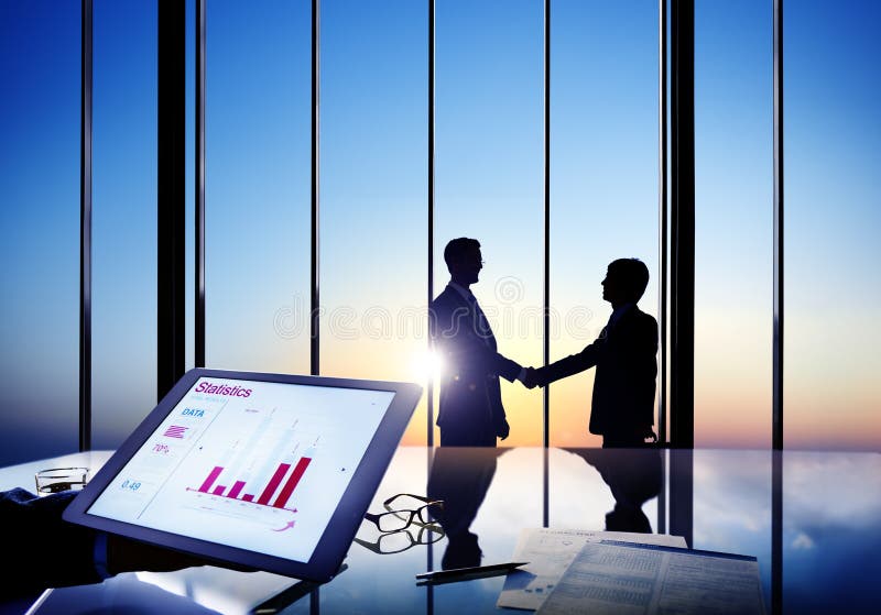 Businessmen Shaking Hands In A Board Room