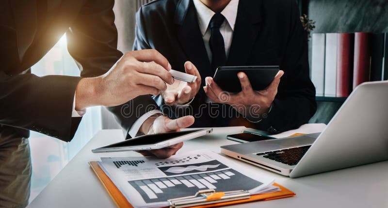 Businessmen team or financial data analysts working with tablets and laptop computers and data graphs together. Plan to analyze projects in the office.