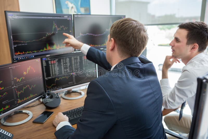 Stock brokers looking at computer screens, trading online.