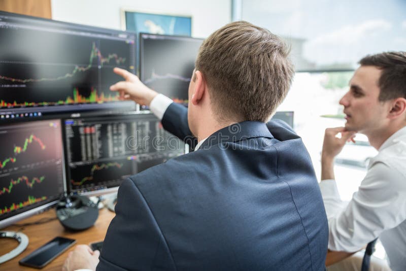 Stock brokers looking at computer screens, trading online.