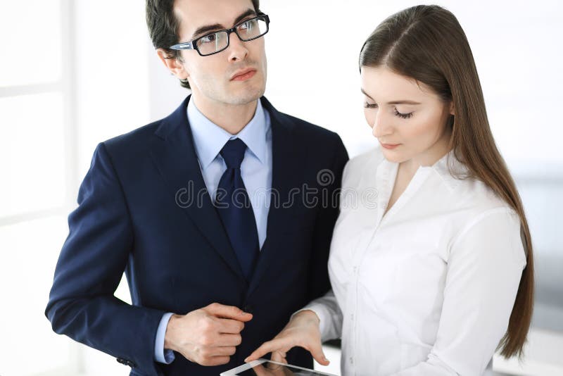 Businessmen and woman using tablet computer in modern office. Colleagues or company managers at workplace. Partners stock photography Businessmen and woman using tablet computer in modern office. Colleagues or company managers at workplace. Partners stock photography