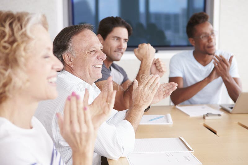 Businesspeople Applauding Colleague In Boardroom. Boardroom table clapping stock images, royalty-free photos and pictures