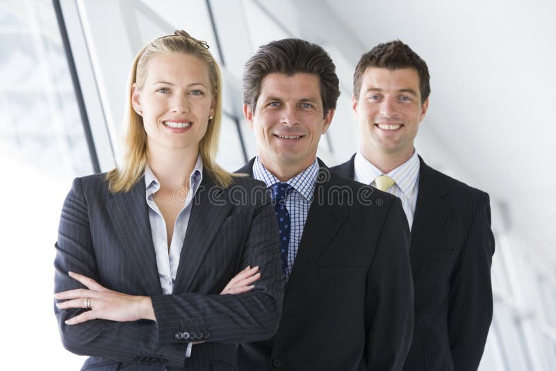 businesspeople corridor smiling standing three στοκ φωτογραφίες businesspeople corridor smiling standing three στοκ φωτογραφίες
